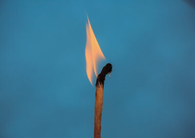 burning matchstick blue background