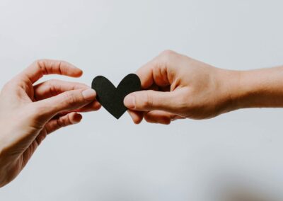 hands sharing a paper heart