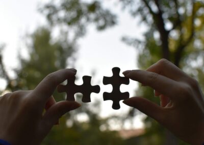 puzzle pieces being connected by two hands