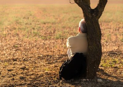 man contemplating next to a tree